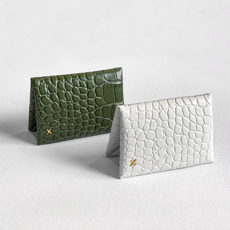Olive croc print leather cardholder and white croc print leather cardholder placed adjacent to each other against a white background. 