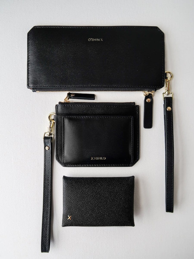 Placed in the order of bottom to top: black croc print leather cardholder, black leather coin purse with card slots and strap, slim black leather wallet with leather strap, genuine leather luxury goods.