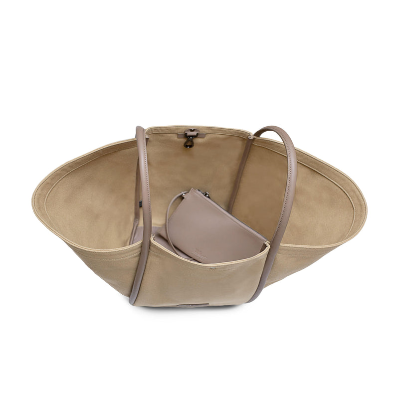 Top inside view of Camel canvas tote bucket bag, with camel rolled leather handles, silver button closure at the top and small square logo of WEST14TH and X NIHILO on the bottom front. Shown with included small Camel leather pouch on the inside.