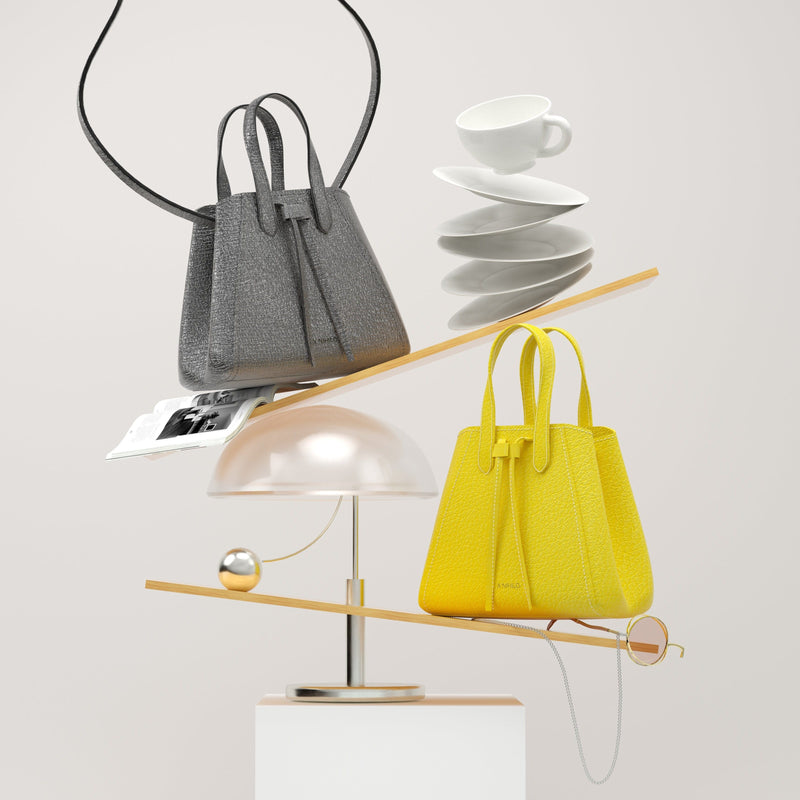 3D detailed composition of two mini leather bucket shape crossbody bags, the X NIHILO Aria bag in gunmetal and lime colors, creating an imbalance with day-to-day regular objects