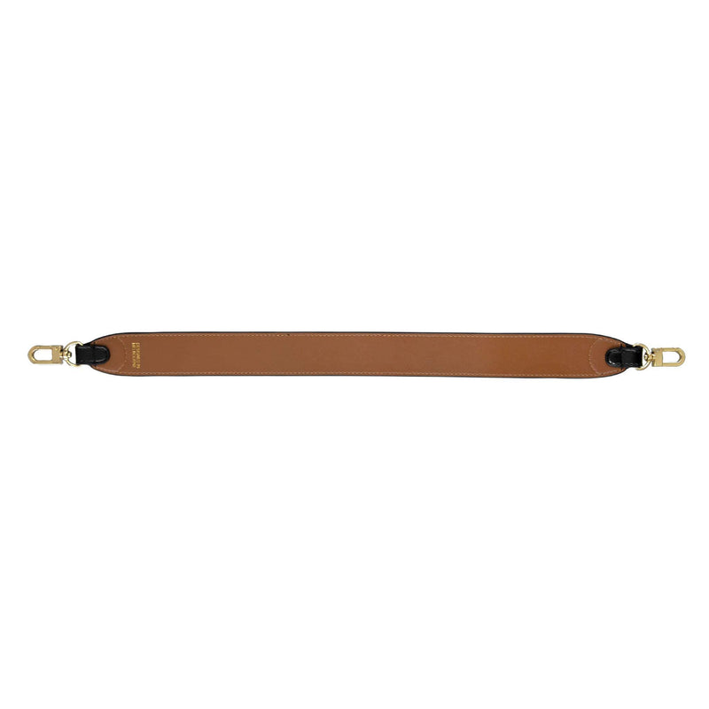 Tan side up of black and tan genuine leather bag strap with gold hardware and X NIHILO logo embossed in gold near clasp.