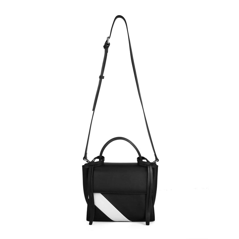 Luxury rectangle genuine black and white cow nappa leather work bag and handbag with black leather tassels, front flap and handle, bag strap is shown extended upward.