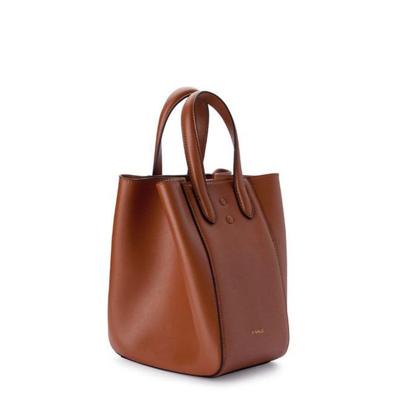 Angled side view of mini tan leather tote bucket bag, genuine nappa leather bag with handle and logo X NIIHILO embossed in gold on the bottom front.
