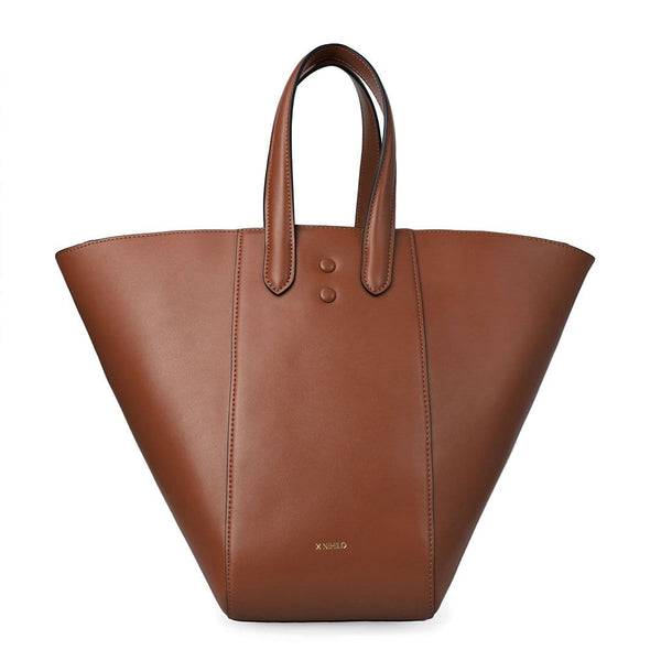 Large luxury tan leather hybrid tote bucket bag, genuine nappa leather bag with handle and logo X NIIHILO embossed in gold on the bottom front.
