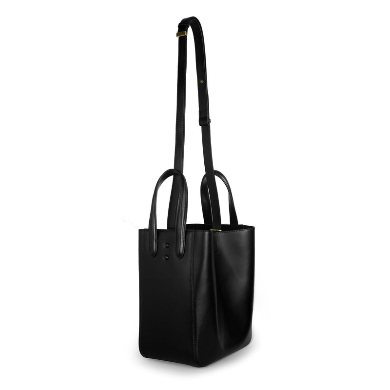 X NIHILO Eight in black bag, genuine nappa leather fashion bag with adjustable shoulder strap, single snap button top closure, and soft gold hardware, luxury cow nappa leather handbag, shown with detachable strap at full length.