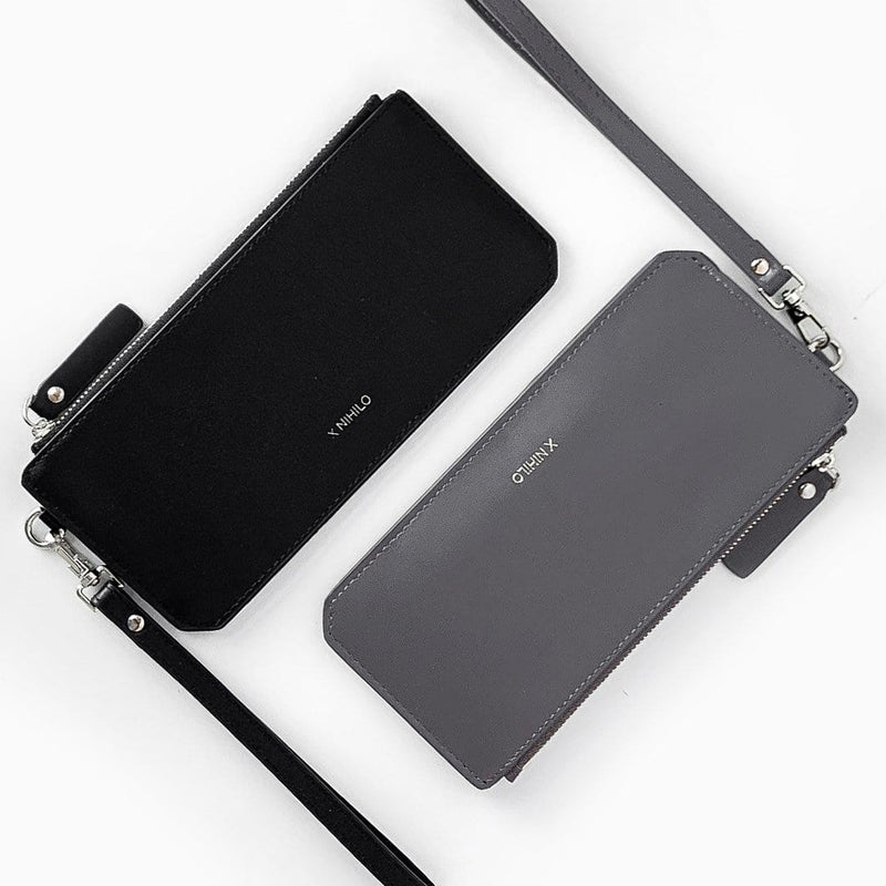 Top view of slim black leather wallet and slim grey leather wallet adjacent to each other, each with a leather strap and logo X NIHILO embossed on the surface, luxury genuine cow nappa leather goods.