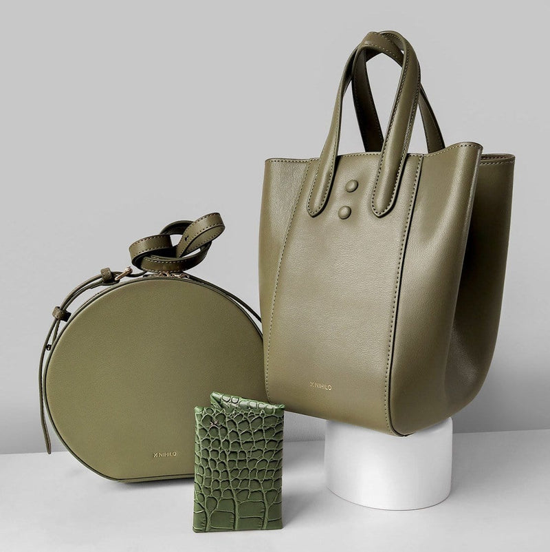 Khaki round leather shoulder bag on the left, khaki leather trapezoid handbag on the right and the olive croc print leather cardholder placed near the bottom centre, genuine leather luxury goods.