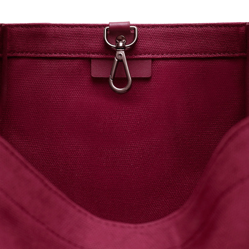 Inside view of Burgundy canvas tote bucket bag, with leather detailing and silver internal clip shown.