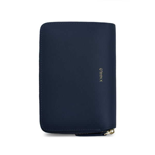 Navy genuine cow nappa leather wallet and passport holder placed vertically with X NIHILO logo embossed in gold on the side.