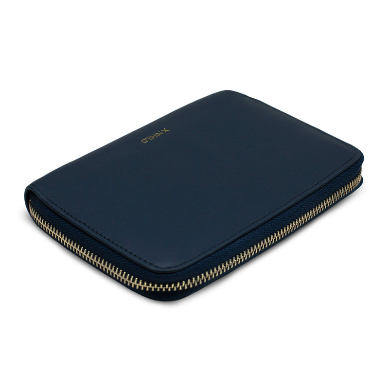 Angled view of navy leather wallet and passport holder with gold zipper detail and logo X NIHILO embossed on the surface.