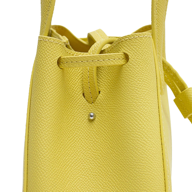 Close up of mini genuine lime color leather detail crossbody bag, Mini genuine lime leather bucket shape crossbody bag with handles and leather pull-strings, X NIHILO Aria bag, textured cow leather with silver hardware, fashion bag