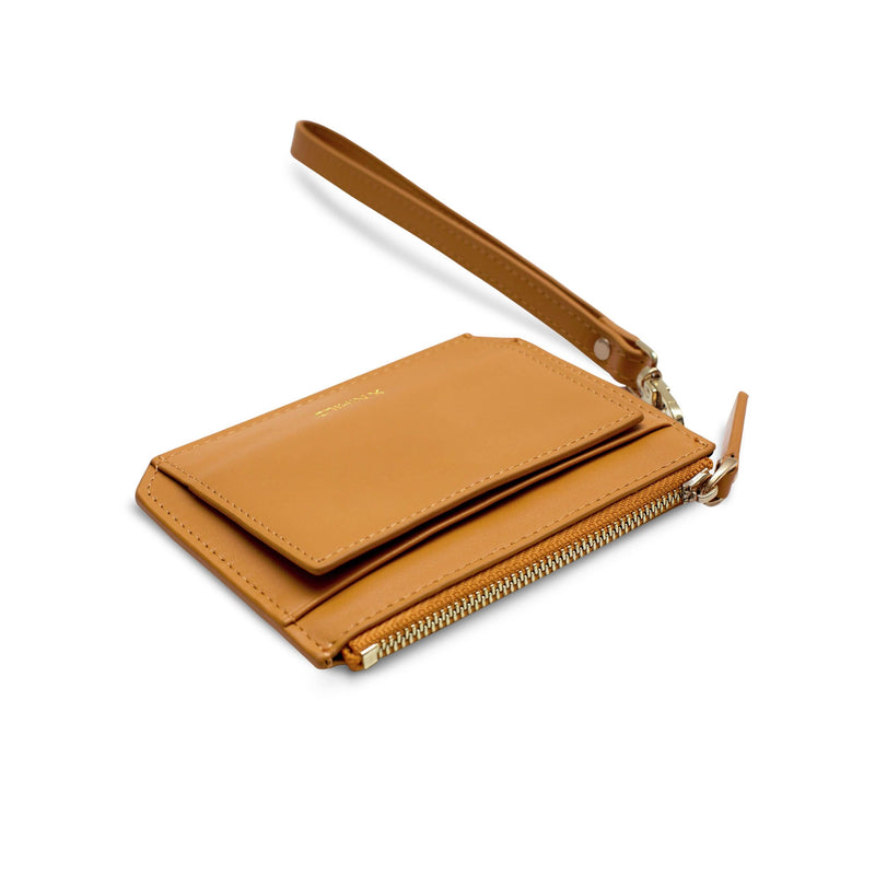 Angled view of small mustard genuine leather coin purse and wallet with detachable leather strap placed on its back.