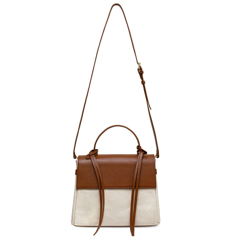 Tan cow nappa leather and natural canvas fabric trapezoid bag with tan leather tassels, front flap and handle, the bag strap extended fully upward, work bag, fashion bag.